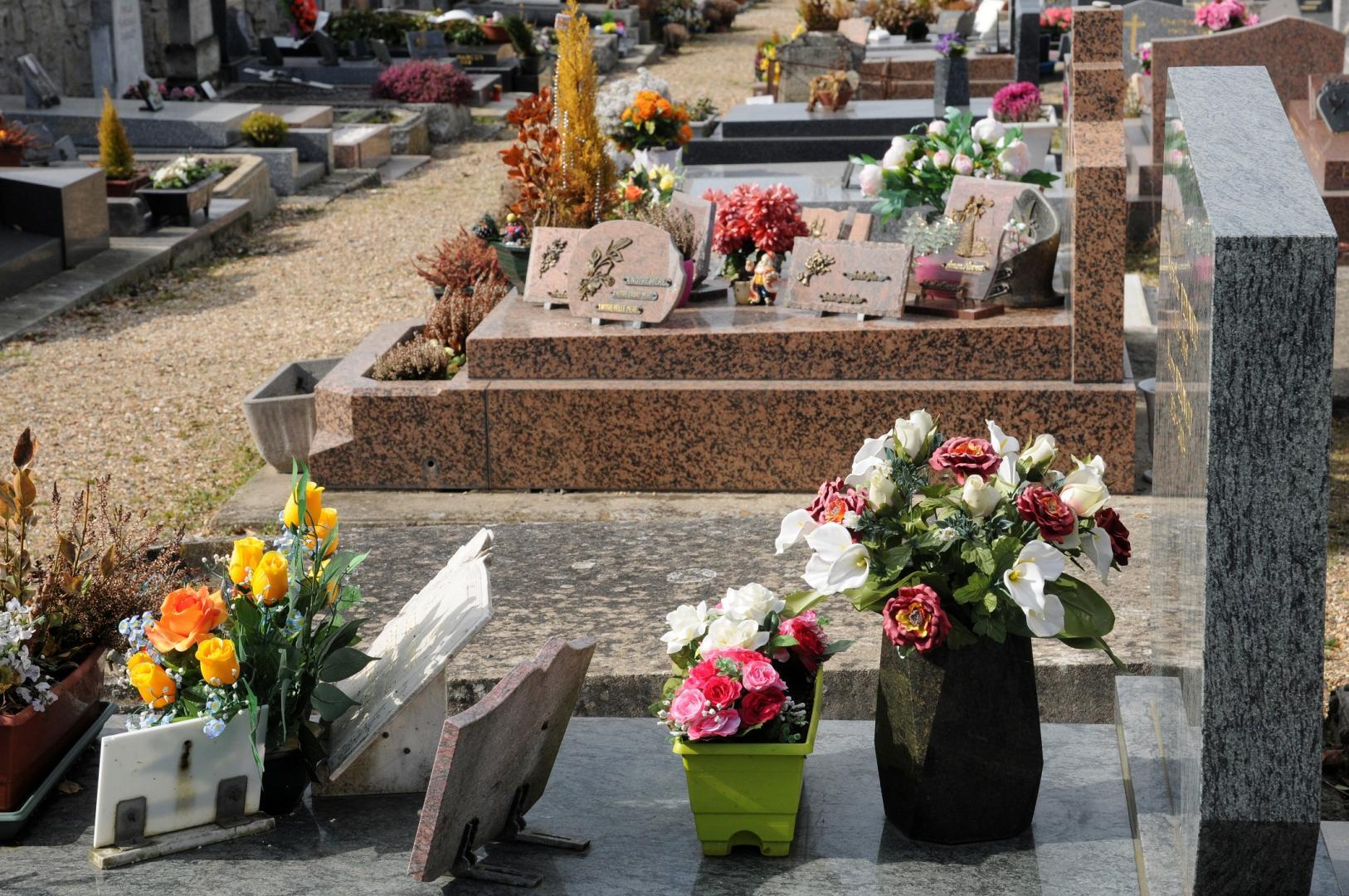 Plaque funéraire personnalisée pour la Toussaint avec une photo du défunt et une citation aimante, placée sur une tombe dans un cimetière automnal